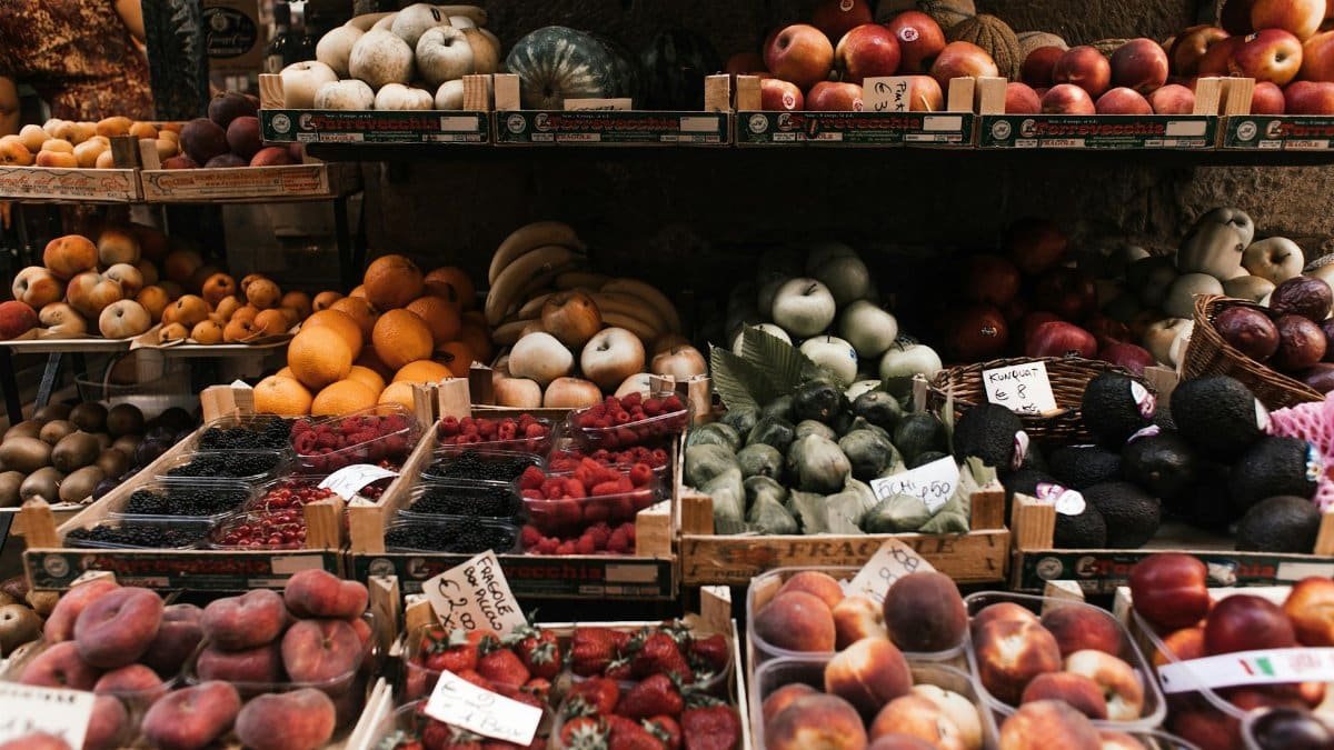 Assorted fresh ripe healthy fruits and berries placed on stall on local market