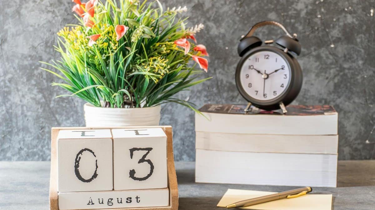 Stylish August 3rd setup with a vintage clock, flower arrangement, and calendar blocks on a desk.