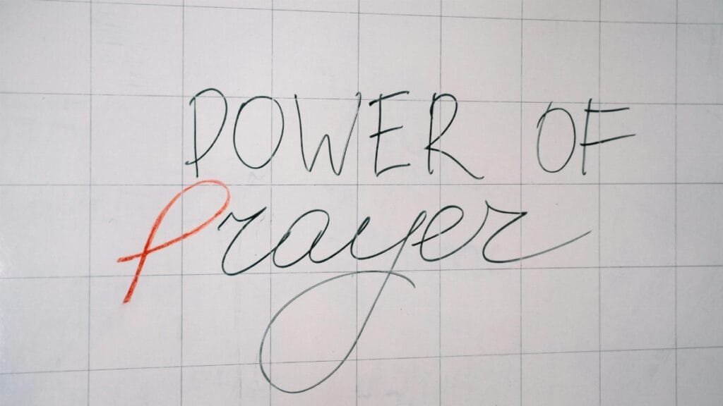Handwritten 'Power of Prayer' message on a tiled surface conveying spirituality and inspiration.
