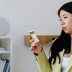 Woman in office attire holding color swatches, contemplating selection.