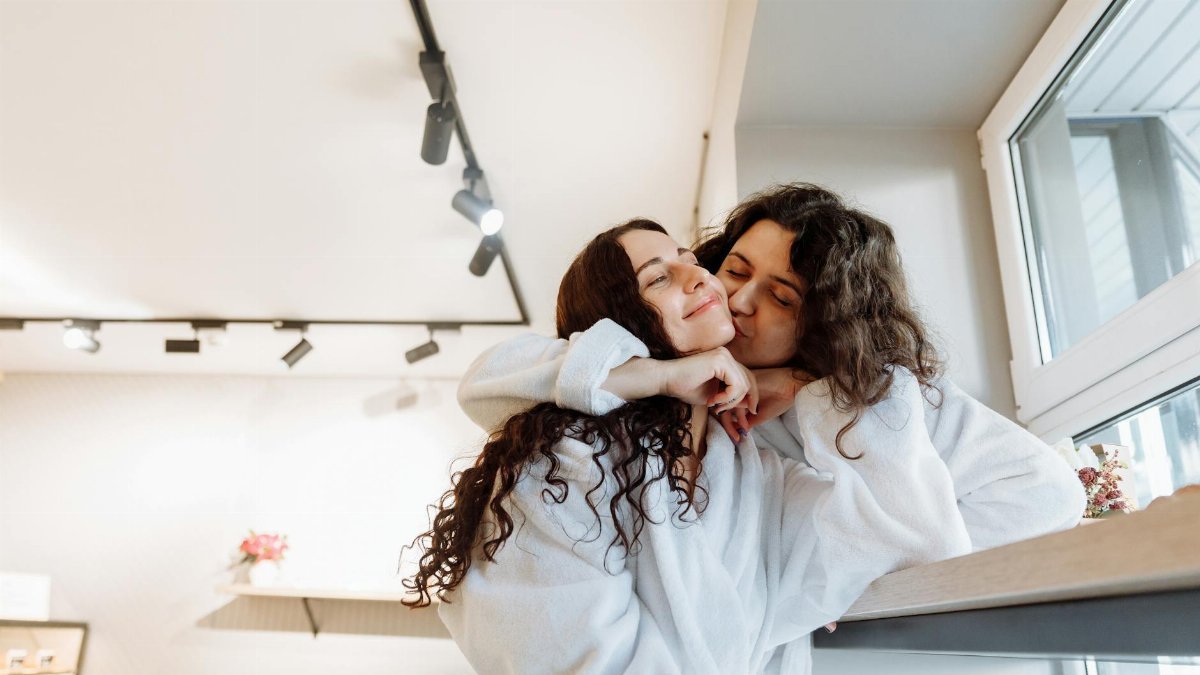 Happy couple shares intimate moment in cozy indoor setting, exuding warmth and closeness.