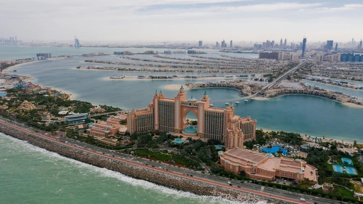 A stunning aerial view of Atlantis The Palm hotel with Dubai's skyline and sea in the background.