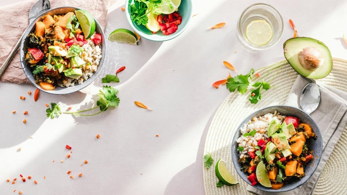Top-down view of vibrant vegan bowls filled with fresh vegetables, perfect for a healthy meal.