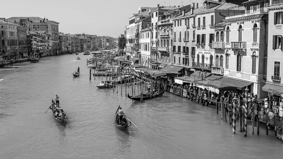 A classic black and white view of gondolas navigating the Grand Canal in Venice, Italy.