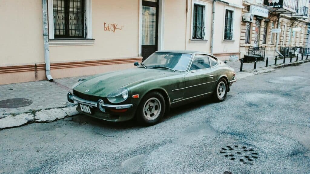 Classic green Datsun car parked on an urban street in Odessa, Ukraine, showcasing retro automotive design.