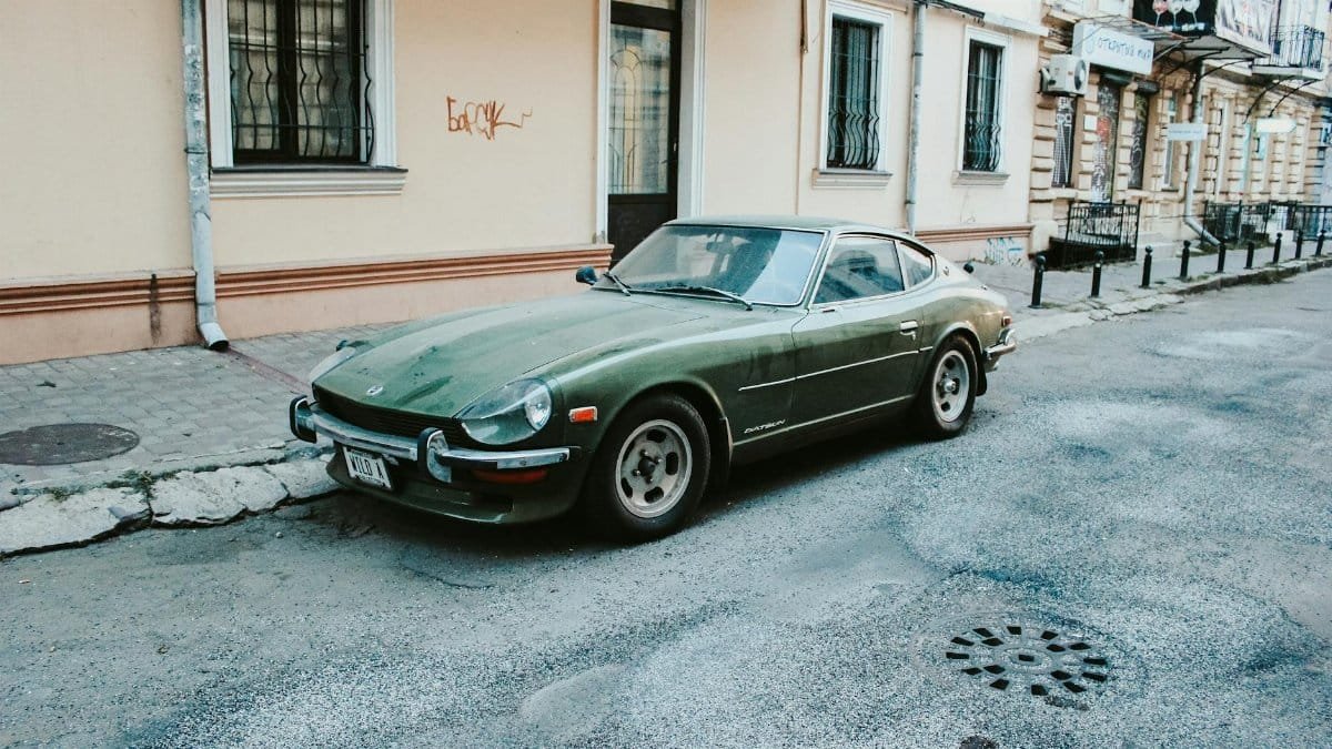 Classic green Datsun car parked on an urban street in Odessa, Ukraine, showcasing retro automotive design.
