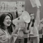 Group of activists protesting with signs and a megaphone for environmental causes.