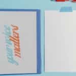 Your Voice Matters binder with blank paper and pen on blue background.