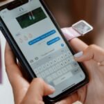 Woman typing on a smartphone, sending a text message with emoji.