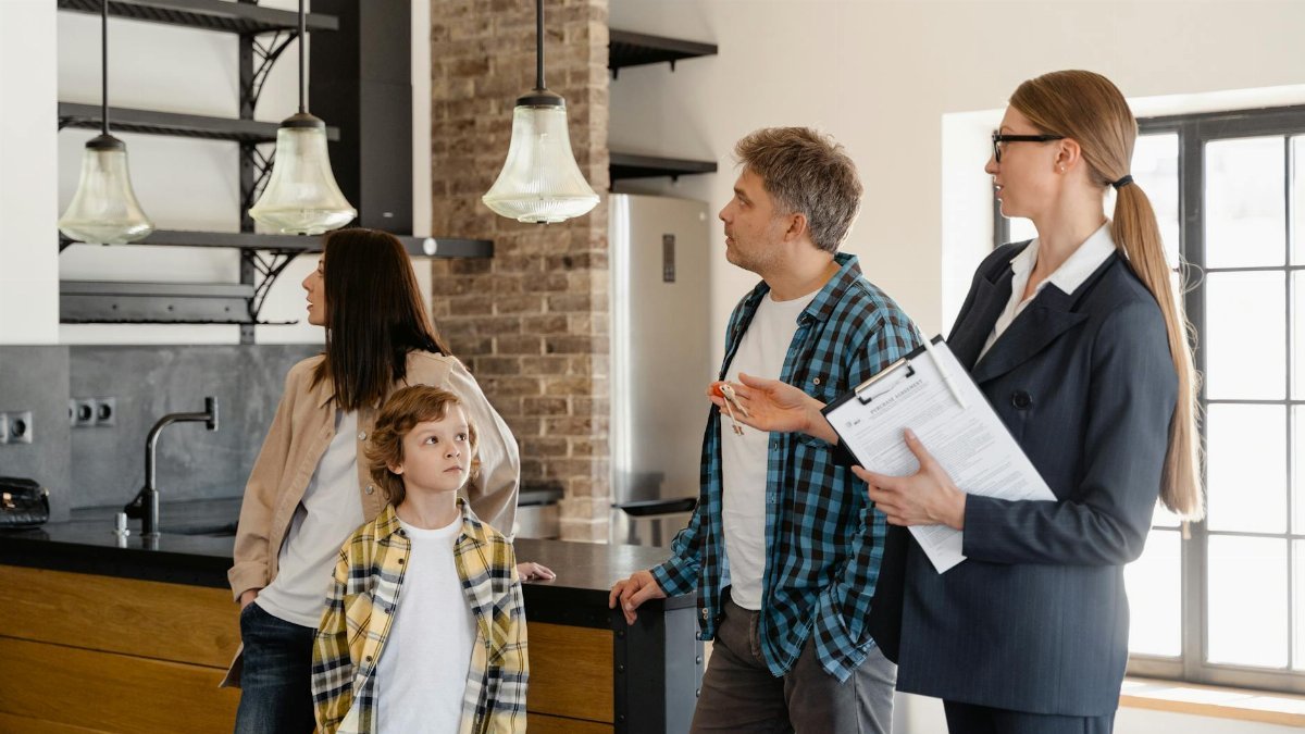 A family converses with a real estate agent about a modern home interior.