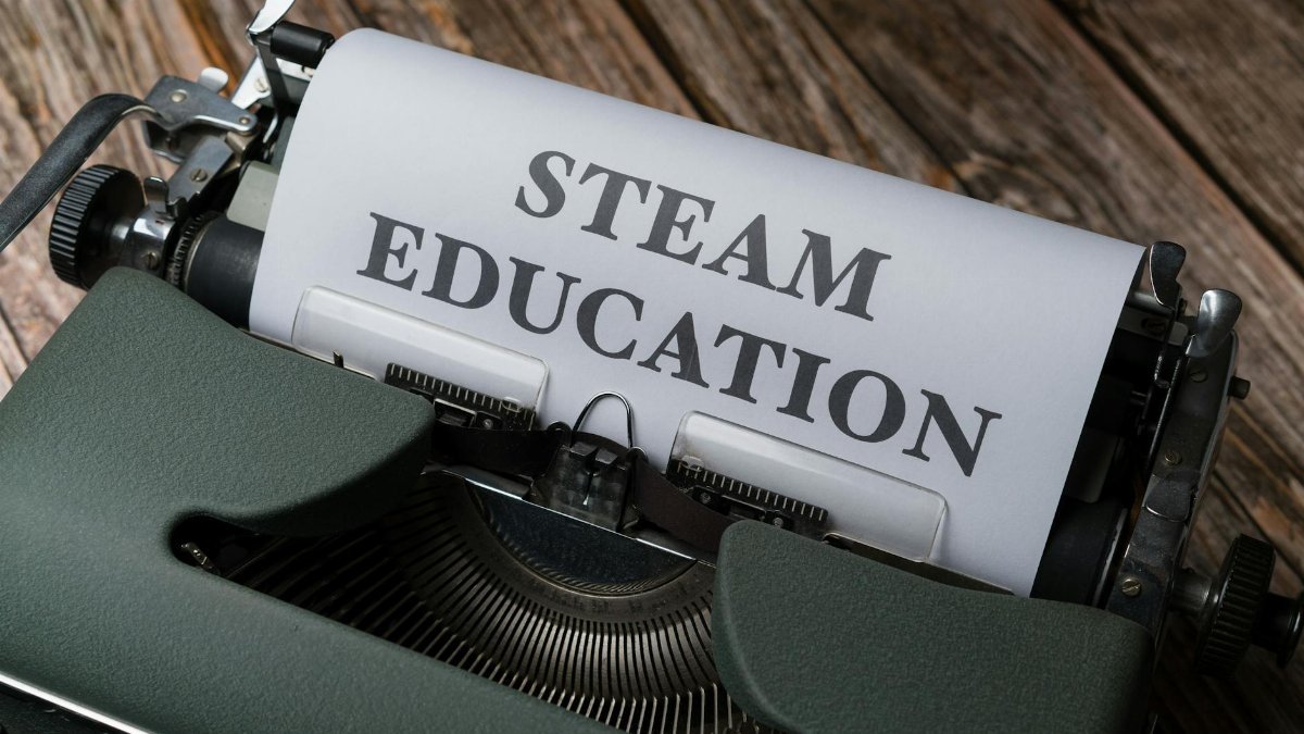 Retro typewriter with 'STEAM Education' paper, symbolizing creativity and innovation.