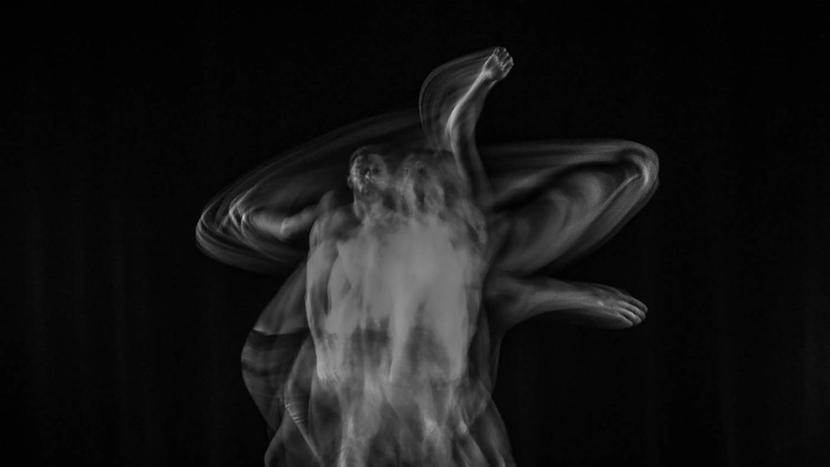 A black and white abstract photo depicting motion blur of a dancer on stage.