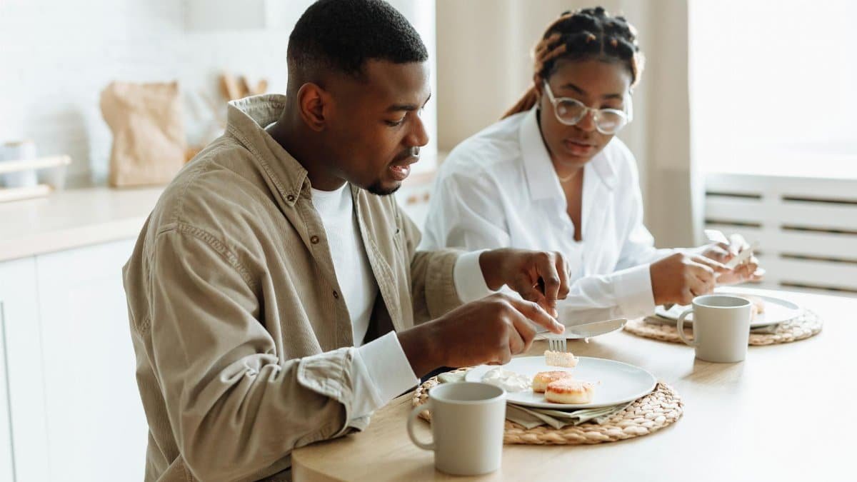 A loving couple enjoying a breakfast meal together at a cozy indoor setting.