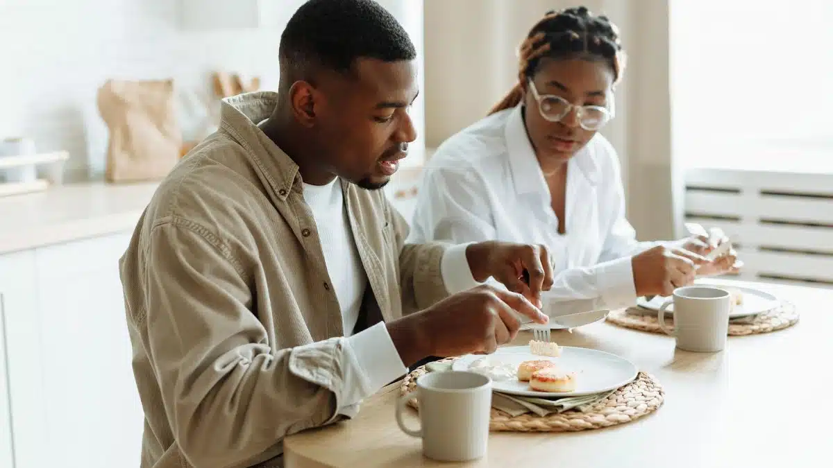 A loving couple enjoying a breakfast meal together at a cozy indoor setting.