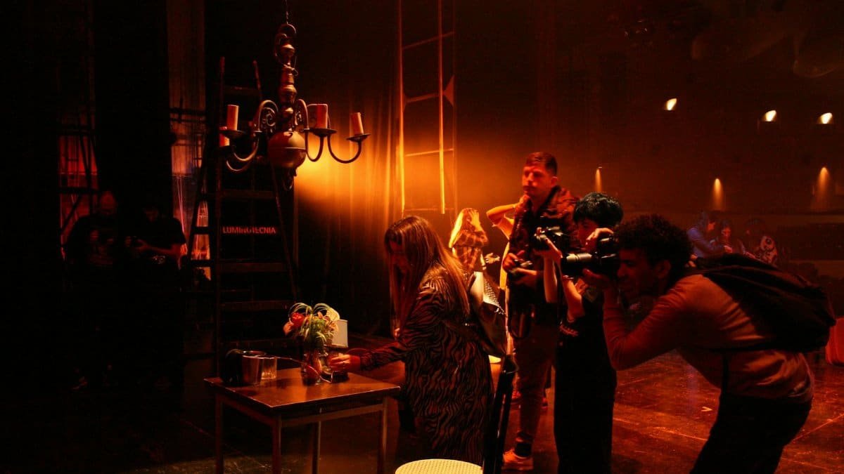 A team of photographers in action on a dramatic theater stage setting.