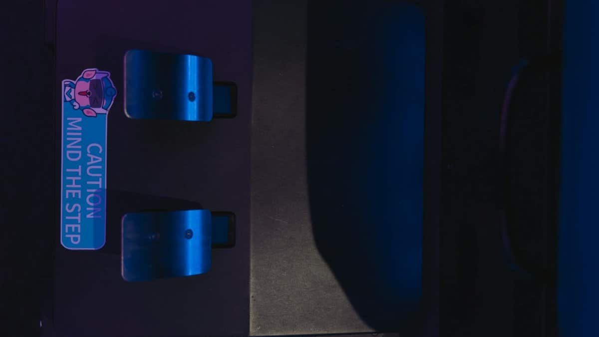 Close-up photo of pedals with a caution sign under blue lighting, highlighting safety.
