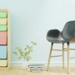Modern minimalist interior featuring a stylish chair and a colorful storage unit.