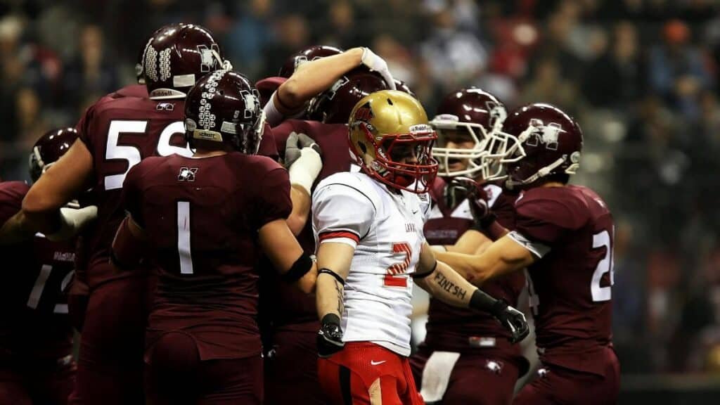 Football players in action celebrating a play on the field during a college game.
