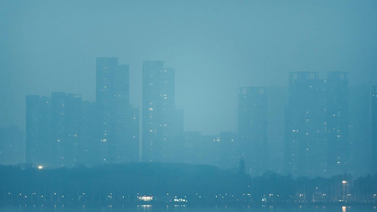 Foggy skyline of a city with skyscrapers and waterfront view.