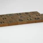 Scrabble tiles spelling 'Pause, Breathe, Resume' on a white background, symbolizing mindfulness and relaxation.
