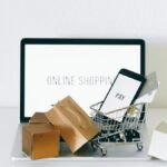 Display of online shopping theme with mini cart and payment devices on laptop.