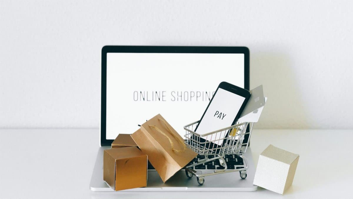 Display of online shopping theme with mini cart and payment devices on laptop.