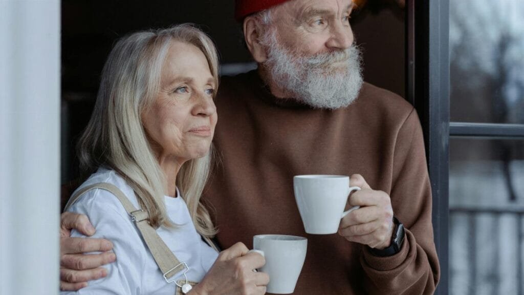 A senior couple embraces while enjoying coffee, symbolizing love and companionship.