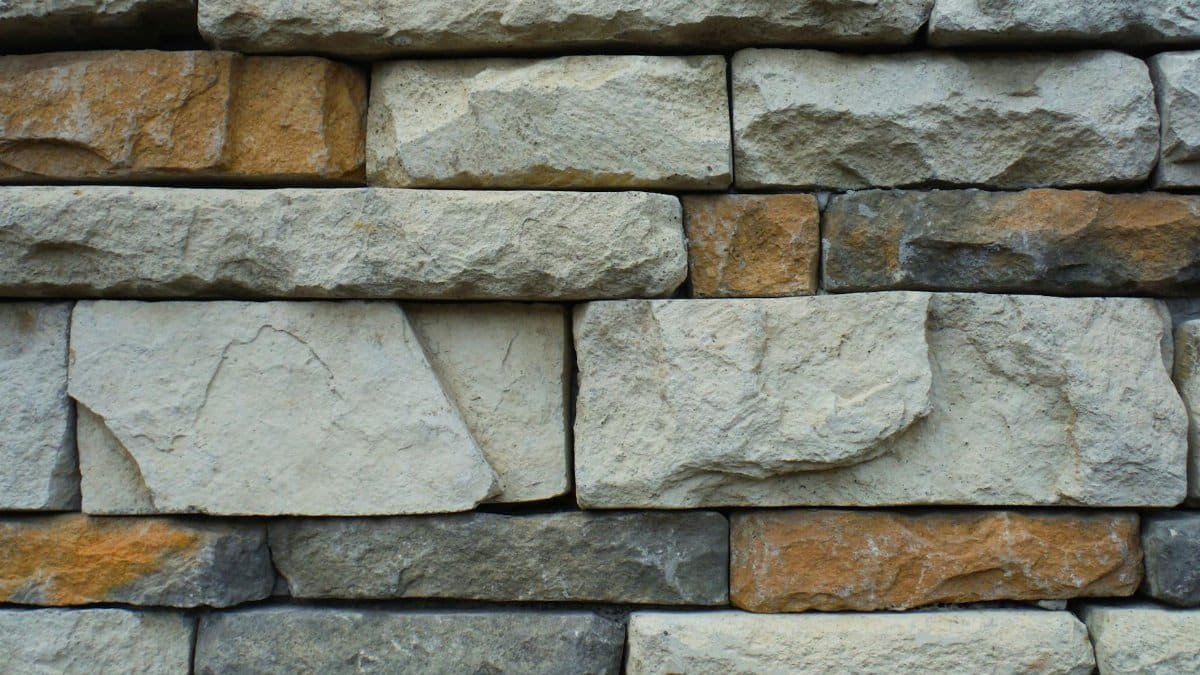 Close-up of a textured stone wall with a variety of natural colors.