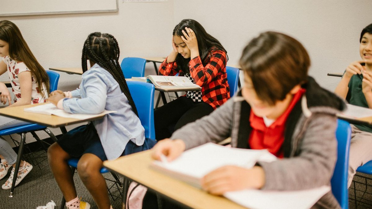 Diverse group of students engaged in study session inside a classroom setting.