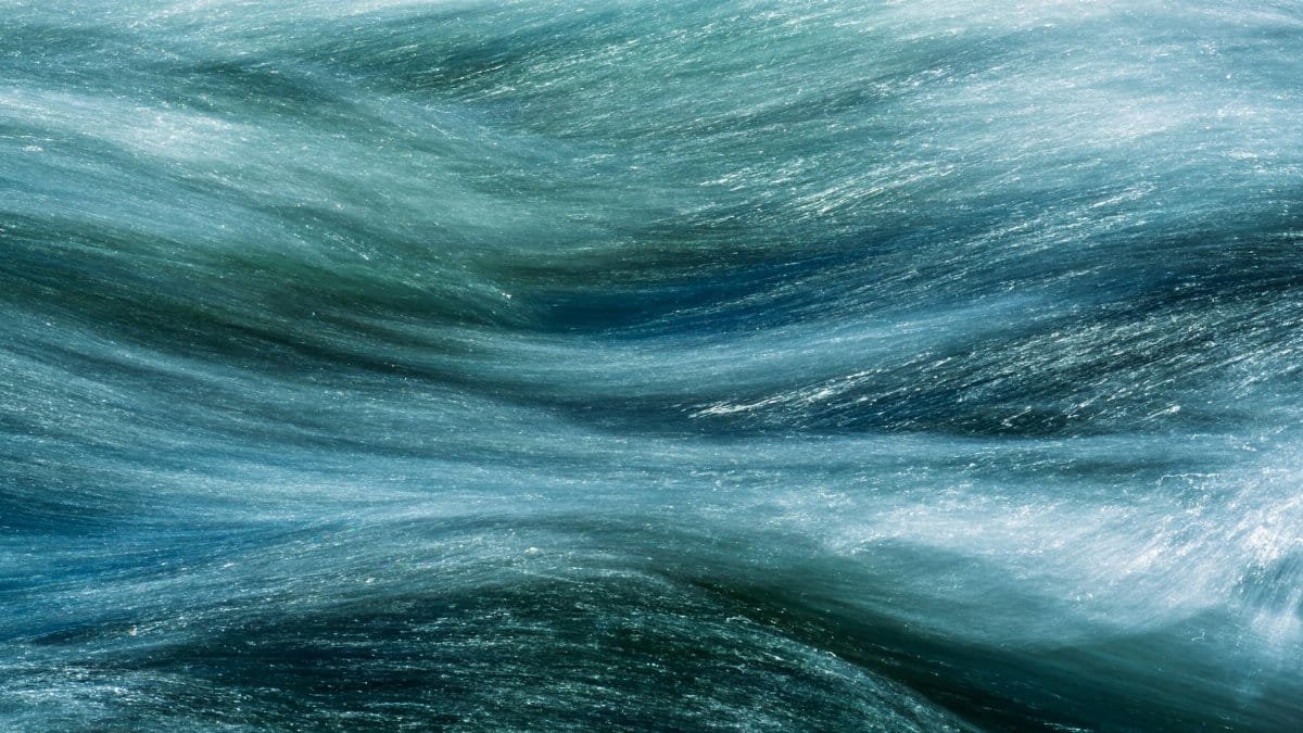 Abstract image capturing the fluid motion of water in a long exposure shot, highlighting its texture and flow.