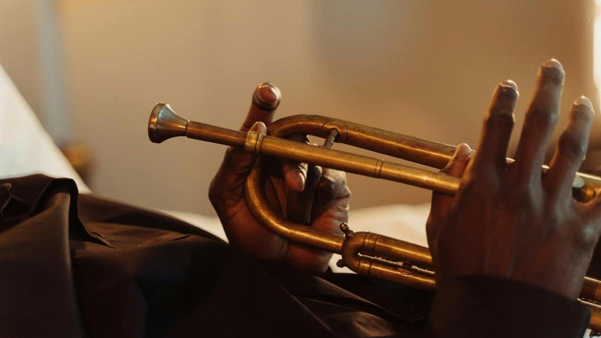 Artistic close-up of hands holding a brass trumpet, showcasing musical craftsmanship.