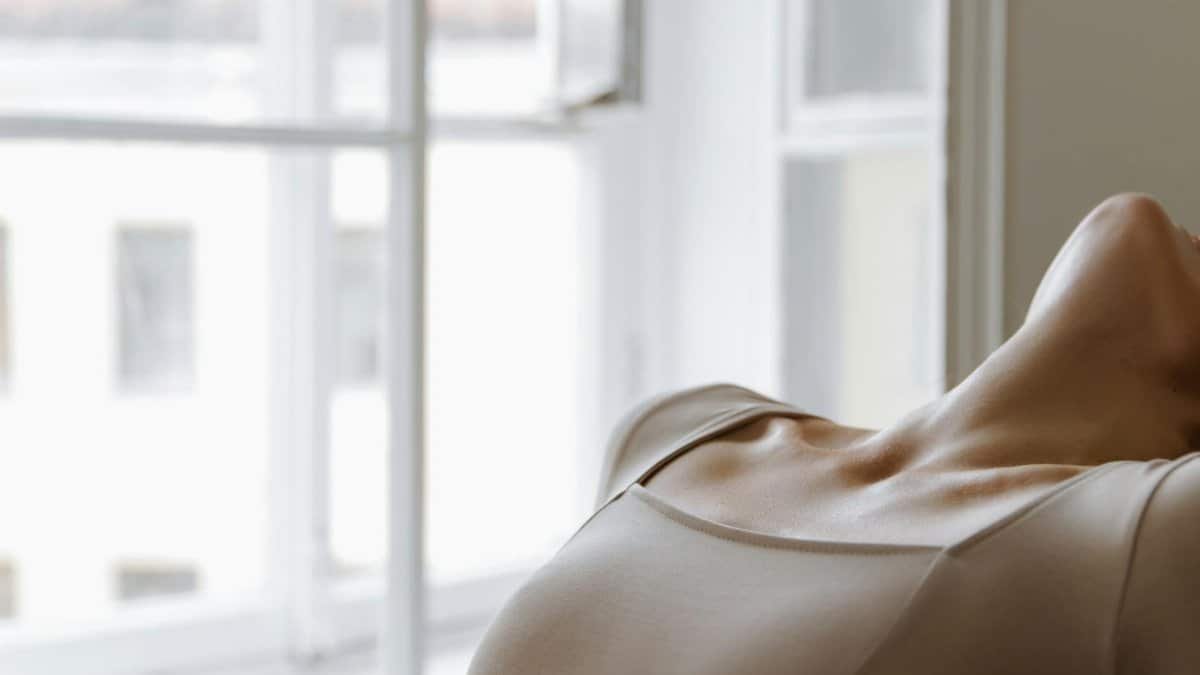 An intimate portrait showcasing a relaxed pose by a sunlit window, conveying tranquility.