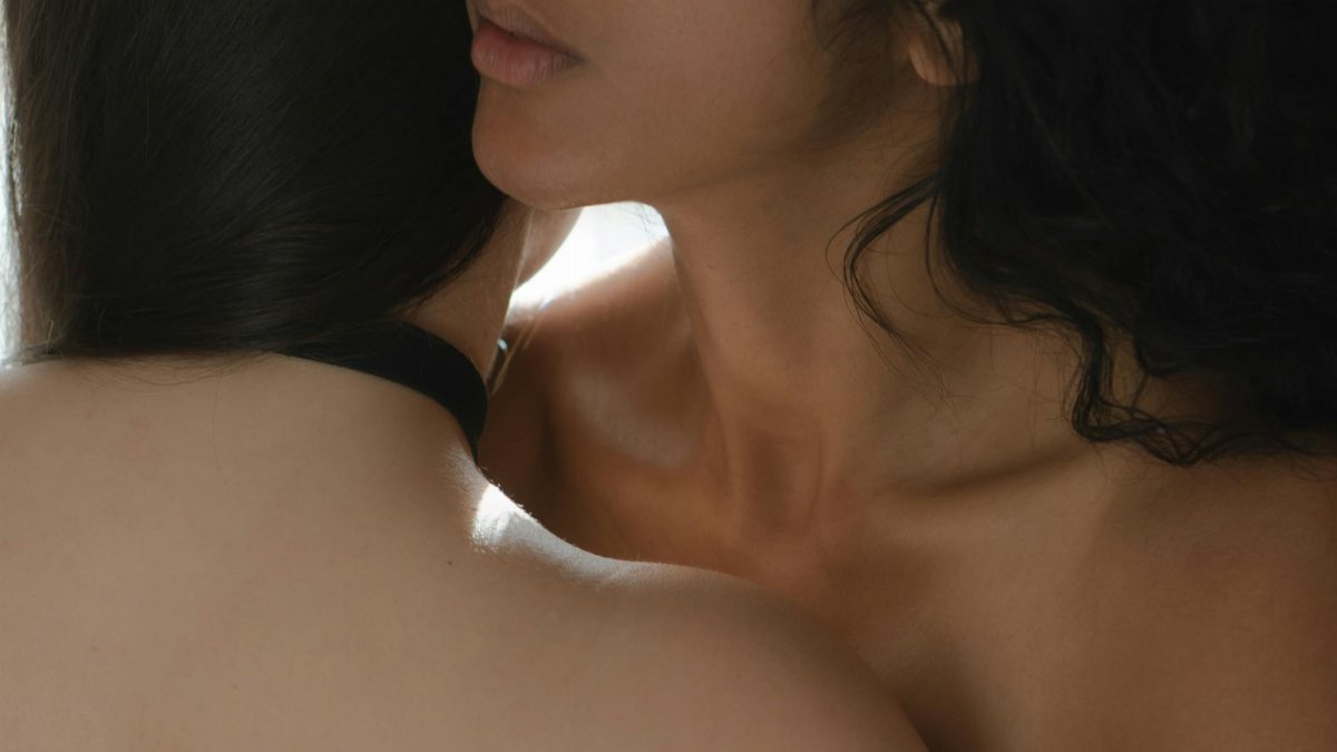 Close-up of two women in a tender embrace showcasing intimacy and connection.