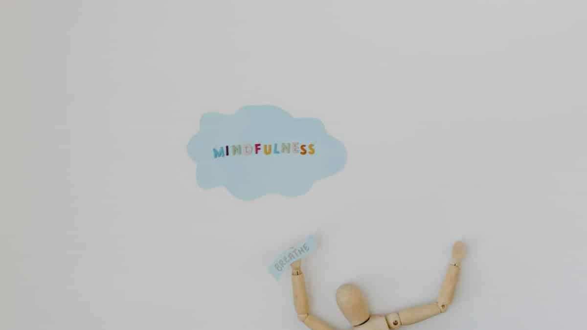 Wooden figure promoting mindfulness and breathing on a clean white background.