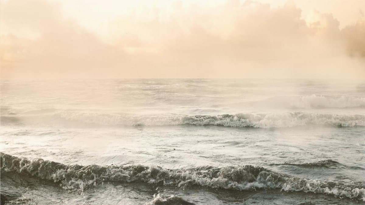Peaceful ocean waves gently rolling under the warm light of sunrise.