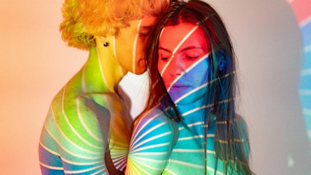 Colorful light patterns on two people, symbolizing love and connection.