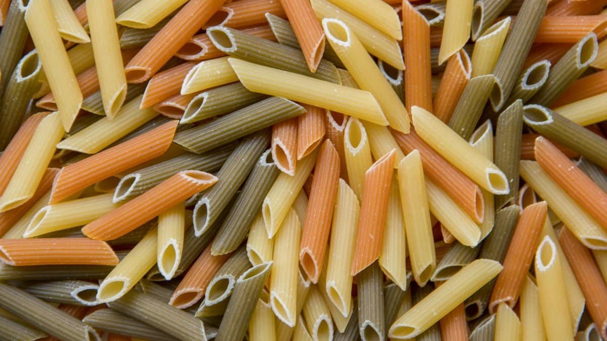 Vibrant close-up of uncooked tri-color penne pasta.