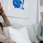 A focused therapy discussion between a male client and female therapist in a serene office.