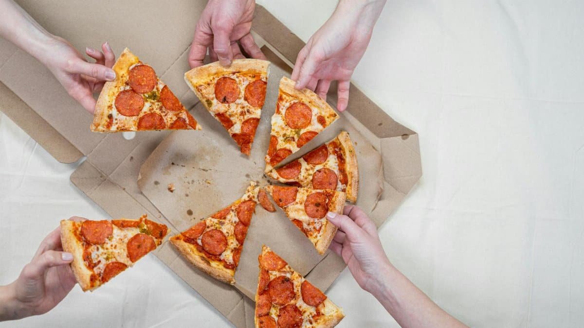 Friends sharing a delicious pepperoni pizza, creating a warm and inviting atmosphere.