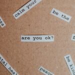 Cut-out words promoting mental health awareness on cardboard background.