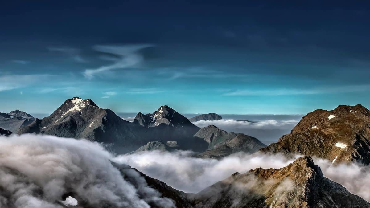 A stunning view of snow-capped mountains in the Lofoten Archipelago surrounded by clouds.