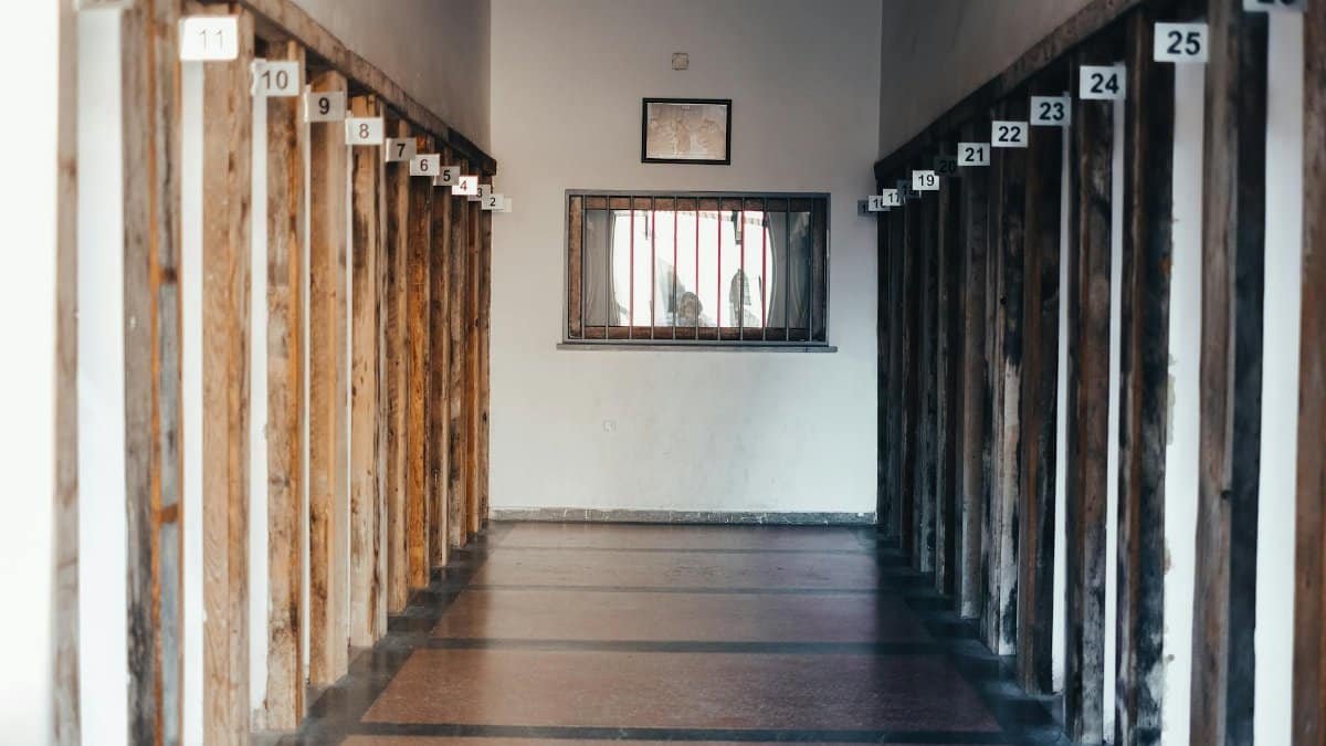 A corridor with wooden walls numbered and a window at the end, photographed indoors.