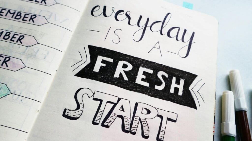Notebook page featuring motivational quote 'Everyday is a fresh start' with colorful pens.