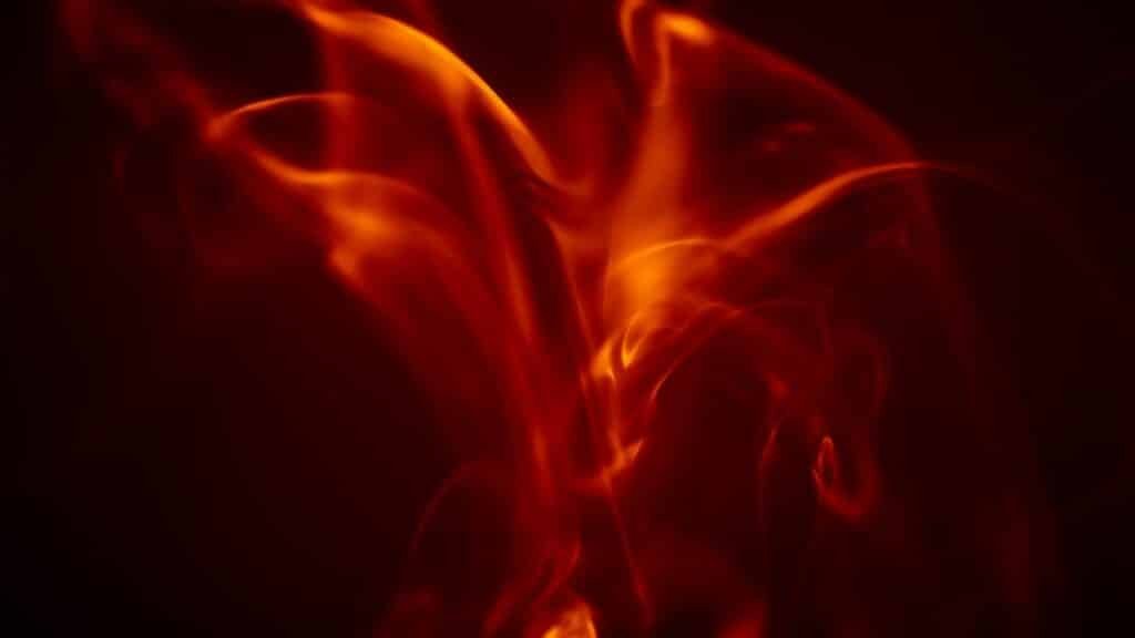 Dynamic abstract image of vibrant orange flames against a dark backdrop, exuding energy and warmth.