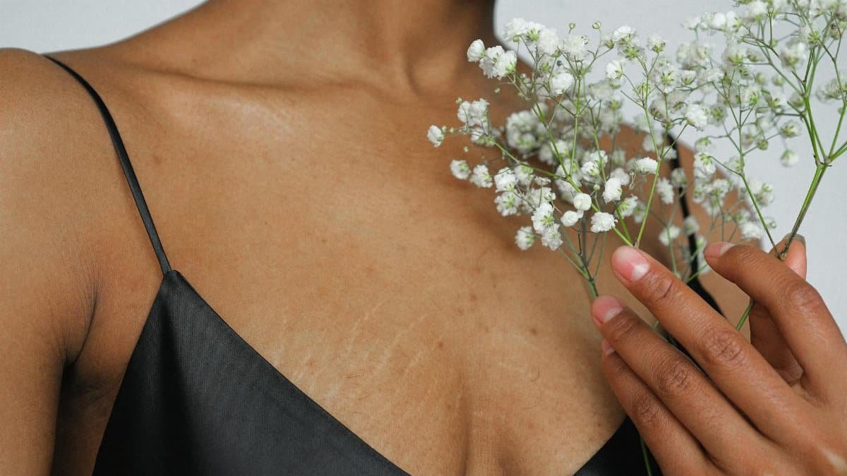 Close-up of an elegant woman in a black dress holding white baby's breath flowers.