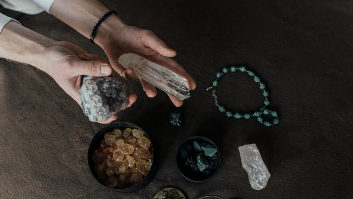 Close-up of hands holding various healing crystals for alternative therapy and meditation.