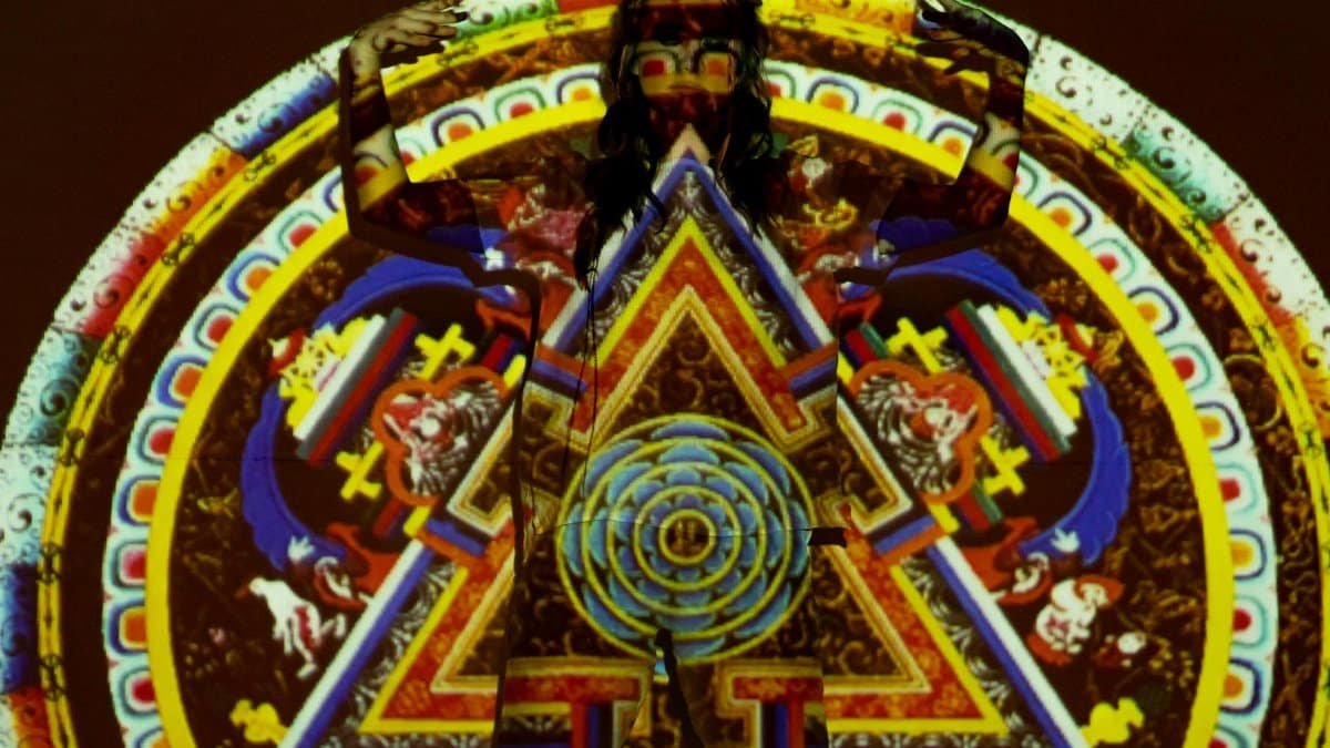 Vibrant psychedelic projection art on a woman with intricate mandala patterns.