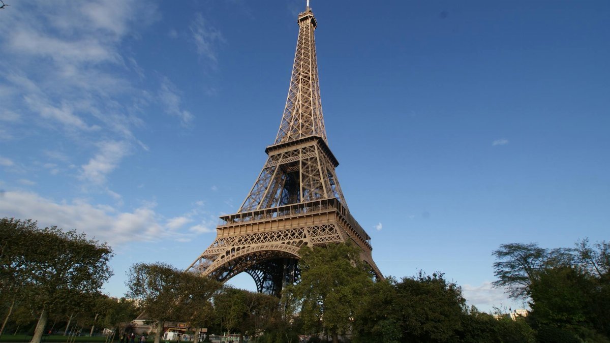 Captivating photo of the Eiffel Tower in Paris, showcasing its grandeur against a clear blue sky.