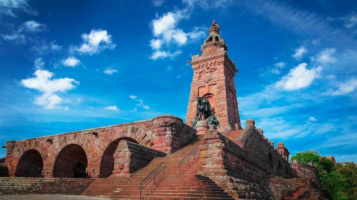 Stunning view of a Gothic-style memorial in Germany against a vibrant blue sky.