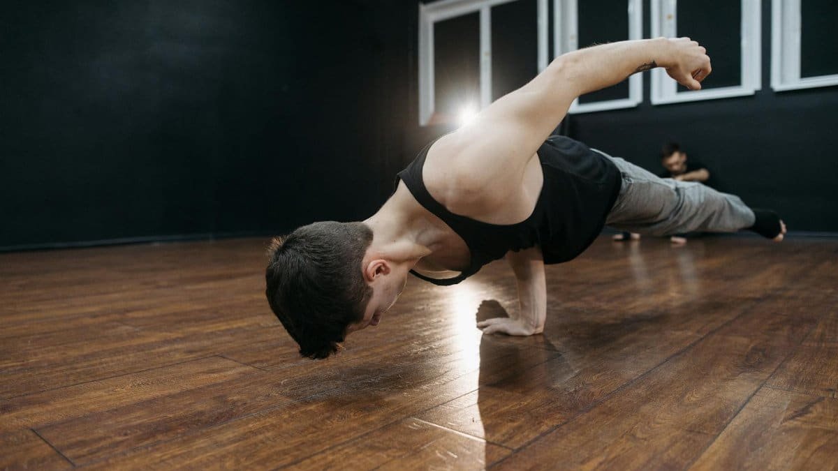 A breakdancer showcasing strength and flexibility in a dance studio.